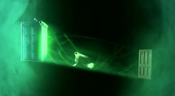 Doctor traveling on green light beam between TARDISes
