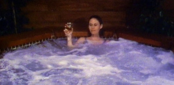 Sybil drinking wine in hot tub